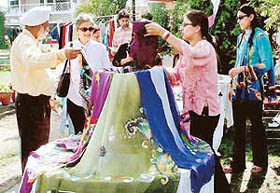 A couple examines hand-printed stoles during Vanity Fair Exhibition, 2004, at Whispering Willows, Zirakpur, on Saturday.
