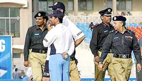 Indias Sachin Tendulkar (front, blue trousers) and coach John Wright (behind, partially hidden), are flanked by Pakistani security personnel during a training session in Rawalpindi on Monday.