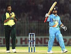 Pakistans Shoaib Akhtar applauds a century knock by Sachin Tendulkar as he raises his bat to acknowledge the cheering crowd in the second one-day international between India and Pakistan in Rawalpindi