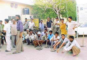 Safai karamcharis wait outside the office of the Kharar Municipal Council to accompany officials to the site where possession of the land was to be given to the civic body