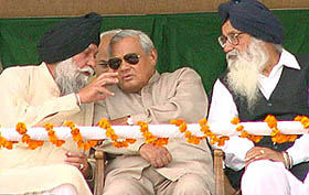 Captain Kanwaljit Singh, former Punjab Finance Minister, makes a point with Prime Minister Atal Bihari Vajpayee at an election rally in Patiala, on Thursday. Mr Parkash Singh Badal looks on.