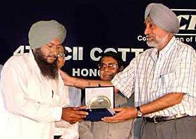 Mr Jai Singh Gill, Chief Secretary, Punjab presents an award to a cotton grower at a function held in Bathinda on Monday.