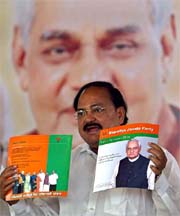 BJP President Venkaiah Naidu displays "Vision Document 2004" in Delhi on Tuesday. 