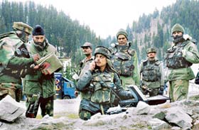 Army personnel use a satellite phone and study maps in Sonamarg during an operation to search for the wreckage of two Jaguar aircraft and the missing pilots
