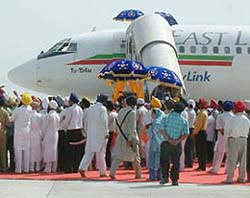 "Birs" of the Guru Granth Sahib are being carried into a chartered flight at Rajasansi airport in Amritsar
