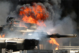 A US Army Abrams tank burns after an attack on a highway junction in the Iraqi capital of Baghdad 