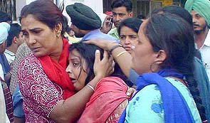 Seema Sharma, mother of Gitanshu Sharma who died in the train-van accident, is consoled by relatives at GTB Hospital in Ludhiana on Wednesday.