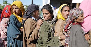 Kashmiri women wait for their turn to cast vote at a polling station in Behibagh.