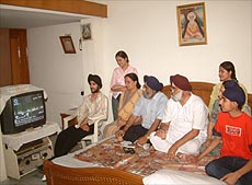 Brothers and family members of Dr Manmohan Singh eagerly await the announcement of Dr Singh becoming the Prime Minister at their residence in Amritsar on Tuesday. 