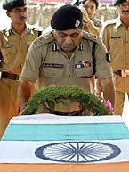 Mr Ajay Raj Sharma, Director-General of the Border Security Force, salutes a coffin of a jawan at a wreath-laying ceremony at Humahama, Budgam, on Monday. 