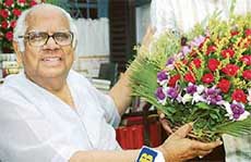 Veteran CPM leader Somnath Chatterjee poses with flowers sent by a supporter at his residence 