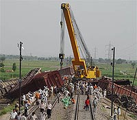 Cranes lift the bogeys of a derailed goods train on the Delhi-Ambala main line at Gharaunda 
