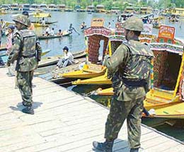 Security personnel keep vigil as tourists enjoy shikara ride in the world famous Dal Lake in Srinagar