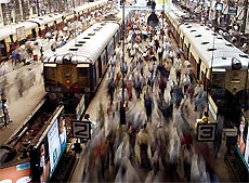 Passengers walk on platforms at a railway station in Mumbai on Tuesday