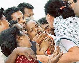 Congress Party President Sonia Gandhi talks to parents of children, who were killed in a fire in a school building