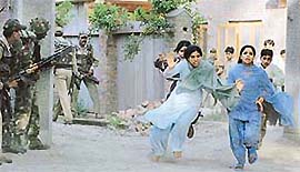 Kashmiri girls run for shelter as soldiers carry out raids in search of militants in the outskirts of Srinagar on Wednesday.  