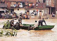 Marooned residents of Rajiv Colony, Panchkula, look for hope as Army personnel try to reach them in a boat on Tuesday. 
