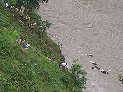 Residents and police officials try to take bodies out of the Beas. A bus fell into the Beas, 28 km from Mandi, on Tuesday. 