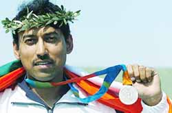 Indias Rajyavardhan Singh Rathore shows the silver medal he won in the mens double trap shooting final at the Markopoulo shooting centre in Athens on Tuesday. 