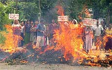 People block a road in Imphal on Wednesday by burning trees and demanding the repeal of AFPSA from Manipur state. 