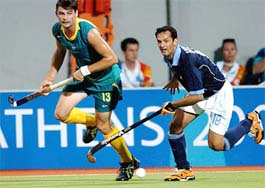 Australias Michael Brennan and Indias Viren Rasquinha run for the ball during a group B hockey match at Athens Olympics on Thursday. Australia won 4-3.