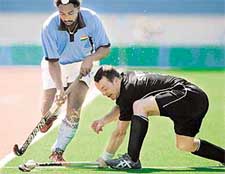 New Zealand's Hayden Shaw tackles Baljit Singh of India during their preliminary hockey match at the Olympic Games in Athens on Saturday. New Zealand won 2-1 to dash Indian hopes of reaching the semifinals. 