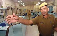Security personnel stand guard at a deserted branch of the State Bank of India during the bank strike in New Delhi on Tuesday.