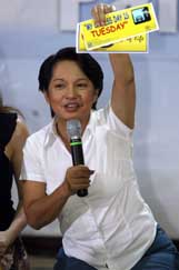 Philippine President Gloria Macapagal Arroyo promotes a car-less day sticker for motorists as she campaigns for energy conservation among the public and government officials in Manila on Saturday