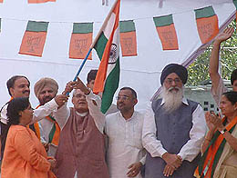 Former Prime Minister Atal Bihari Vajpayee takes the flag from Uma Bharti on the conclusion of the Tiranga Yatra at a rally in Amritsar