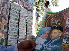 A Pakistani reads a magazine with pictures of Pakistani President Pervez Musharraf and Prime Minister Manmohan Singh at a book stall in Islamabad