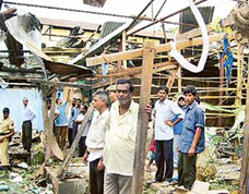 Shopkeepers stand beside the damaged market after a blast in Dekiajuli, about 120 km south of Guwahati, on Sunday. 