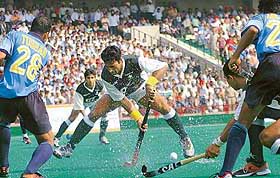 Pakistans star player Sohail Abbas tries to clear the ball past the bunch of Indian players during the hockey Dosti Series-2004 at the Sector 42 Hockey Stadium in Chandigarh on Wednesday.