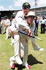 Man of the Match and Australian allrounder Michael Clarke is carried by his senior team member leg spinner Shane Warne after their team won the first Test match by 217 runs against India in Bangalore on Sunday. 