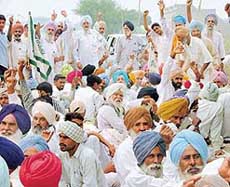 Activists of The BKU (Ekta) block the road leading to Chathewala village in Bathinda on Tuesday to prevent the entry of government officials. 
