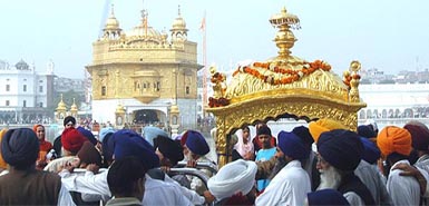 Guru Granth Sahib is taken out in a golden palanquin in a procession on the eve of the 535th birth anniversary of Guru Nanak Dev at the Golden Temple 