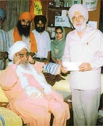 Sant Baba Ajit Singh Hansaliwala presents a cheque to Mr Boparai, VC of Punjabi University, Patiala.