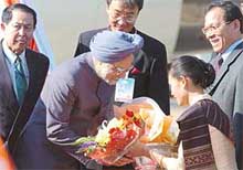 Prime Minister Manmohan Singh is presented a bouquet on his arrival at Vientiane airport in Laos on Sunday. 