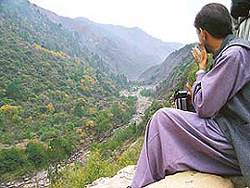 A Pakistani official looks at the broken bridge that links India and Pakistan over the Line of Control at Chakothi in Occupied Kashmir