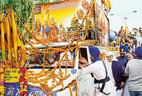 A decked-up vehicle with the photo of Guru Gobind Singhs Sahibzadas and mother passes through Chandigarh on its way from Nadha Sahib to Chamkaur Sahib
