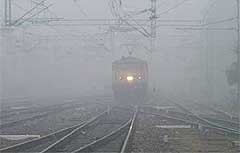 A train makes its way through thick fog in Ludhiana on Sunday. Fog disrupted air and train traffic in northern India on Sunday.