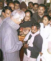 NDA convener George Fernandes with a man holding a currency note at a hospital in Muzaffarpur
