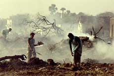 Tsunami survivors search for valuables amid burning houses at a hamlet in Nagapattinam, 350 km from Chennai, on Thursday.