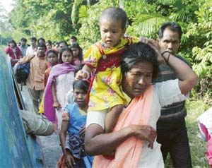 A woman carries her daughter as she leaves the Car Nicobar island.