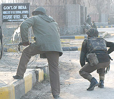 Security personnel take position during an encounter with militants in Srinagar on Sunday.