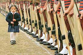 A young girl walks in front of policemen during a full dress rehearsal for the Republic Day parade in Jammu on Monday.