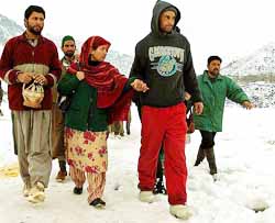 Passengers walk to board a helicopter on Thursday after remaining stranded on a key highway in Banihal