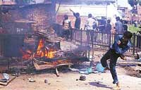 A boy throws stones during clashes between Shias and Sunnis in Lucknow on Sunday. Three men were killed during a tazia procession. 