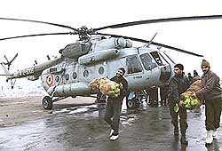 Policemen unload vegetables from an Indian Air Force chopper at an Army airfield in Srinagar on Monday.