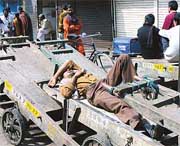 A labourer sleeps in front of closed shops in New Delhi on Monday during a bandh in protest against the imposition of VAT. 