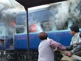 Fire Brigade employees extinguish the fire which engulfed a rail coach in a workshop in Amritsar